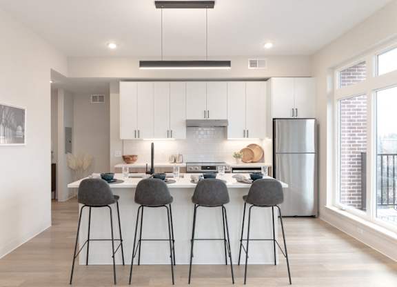 A modern kitchen with white cabinets and a large island.