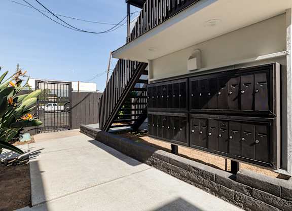 A black metal gate with a white door is closed.