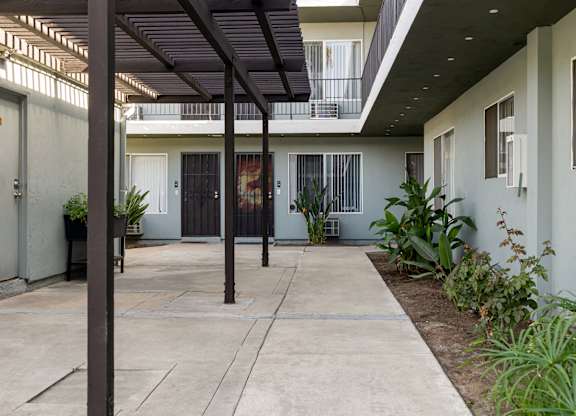 A patio with a black awning and a concrete floor.