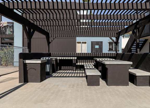A modern outdoor seating area with a wooden pergola.