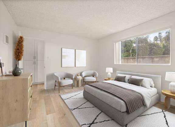 A bedroom with a large bed, a chair, and a nightstand.