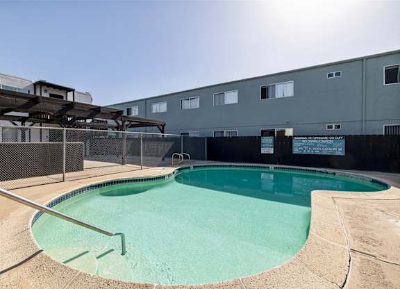 A small pool with a metal fence around it.