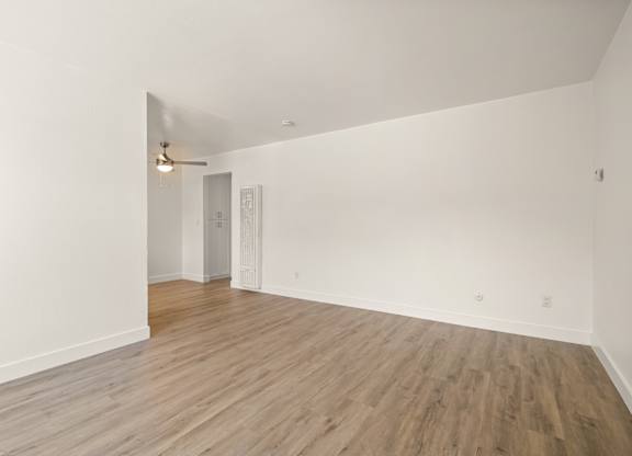 A room with wooden flooring and white walls.