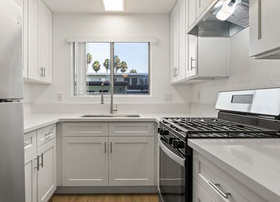 A kitchen with white cabinets and appliances.