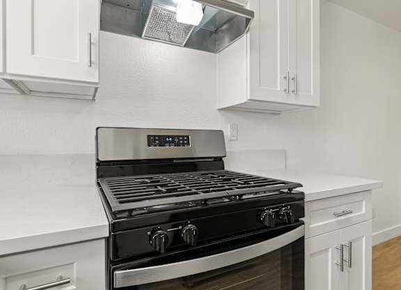 A modern kitchen with a black stove top oven.