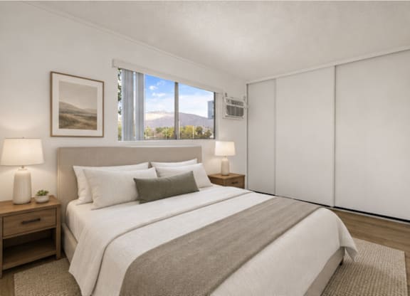 A bedroom with a large bed, two lamps, and a picture on the wall.