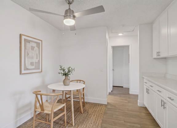 A dining room with a table and chairs.