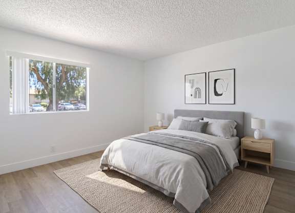 A bedroom with a large bed and two pictures on the wall.