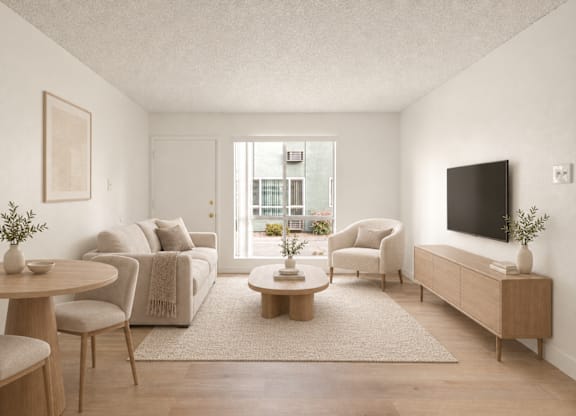 A living room with a couch, chairs, a coffee table, and a television.