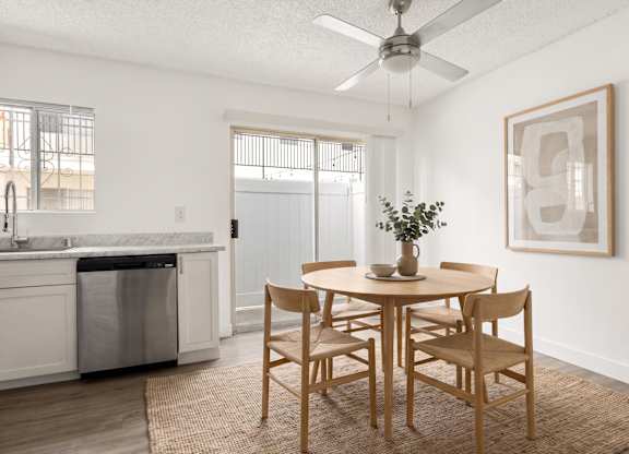 A dining room with a table set for two and a plant on the table.