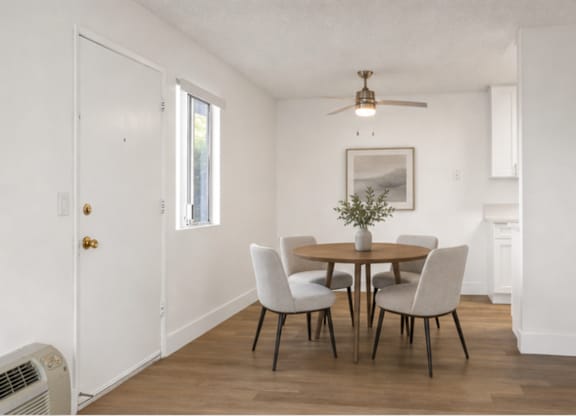 A dining room with a table set for four.