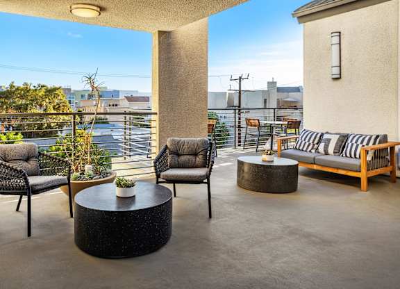A patio with a table and chairs overlooking a cityscape.