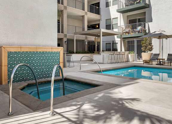 A pool with a diving board in front of a building.
