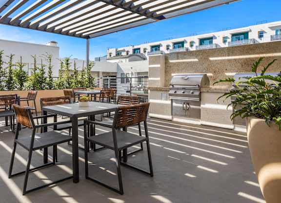 A patio with a table and chairs under a striped awning.