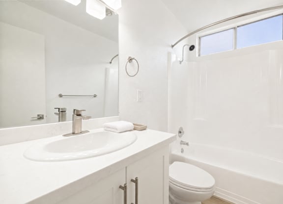 A white bathroom with a sink, toilet, and bathtub.