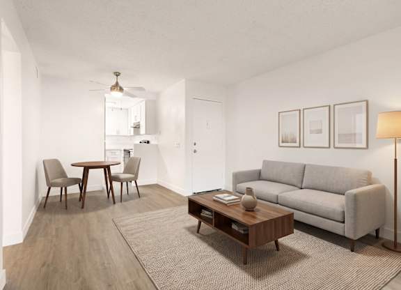 A living room with a grey couch, a coffee table, and a dining table with chairs.