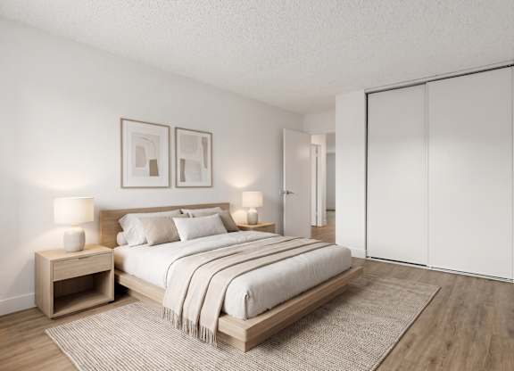 A bedroom with a large bed, two nightstands, and a rug.