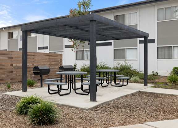 A patio with a table and chairs under a roof.