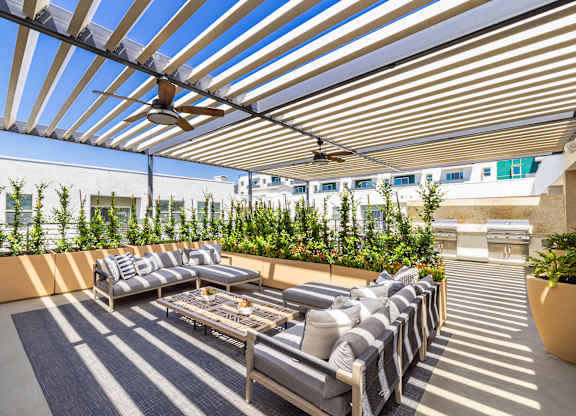 A patio with a striped rug and a striped awning.