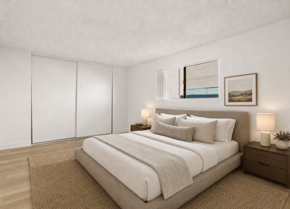 A bedroom with a large bed, a nightstand, and a framed picture on the wall.