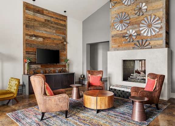 A living room with a fireplace and a wooden wall.