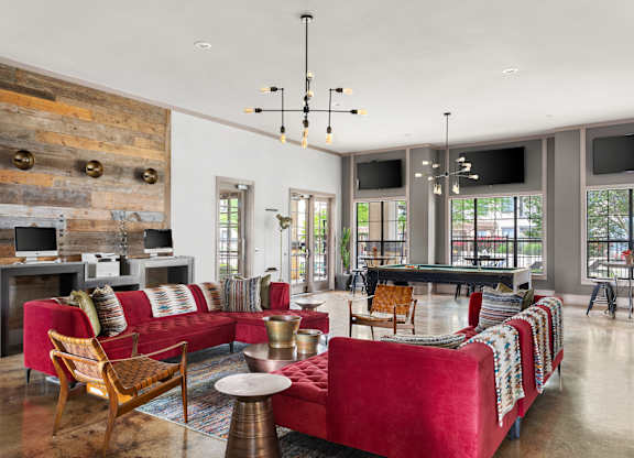 A living room with a red couch and a wooden wall.