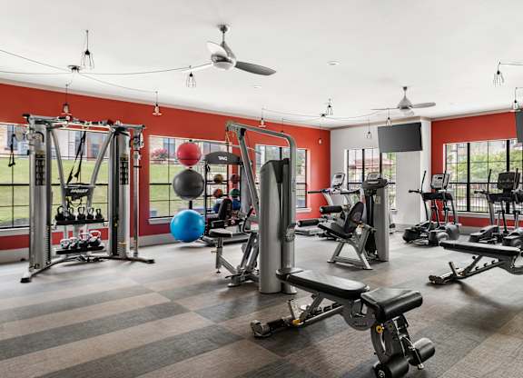 A gym with a variety of equipment including weights and a bench press.
