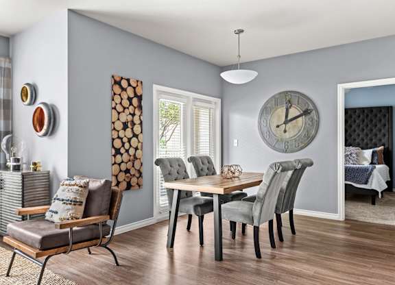 A grey and white dining room with a wooden table and chairs.