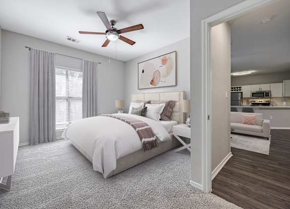 A bedroom with a large bed and a ceiling fan.