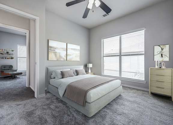 A bedroom with a bed, dresser, and window.