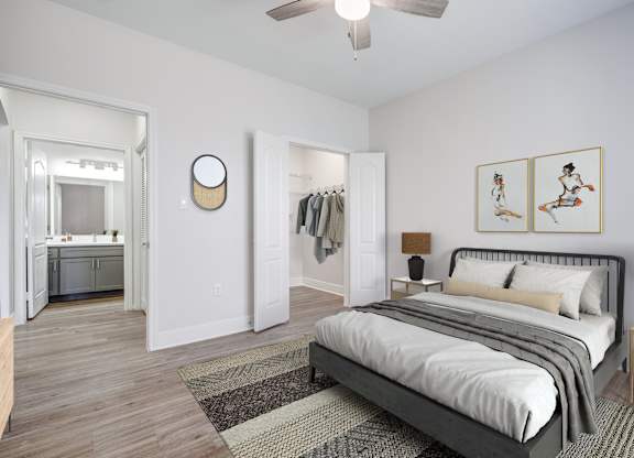 A bedroom with a large bed and a ceiling fan.