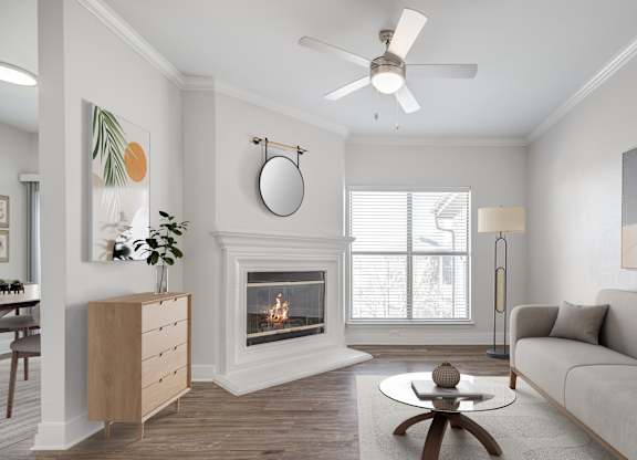A living room with a fireplace, a couch, and a ceiling fan.