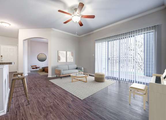 A living room with a couch, chair, and a fan.