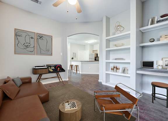 A living room with a brown leather couch and a chair.