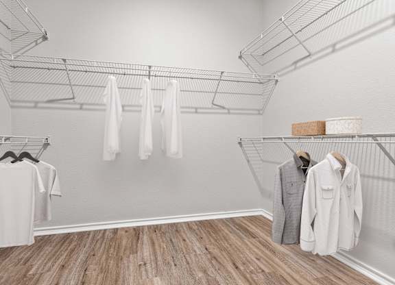 A white shirt is hanging on a rack in a room with wooden floors.