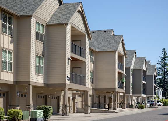 A row of modern townhouses with balconies and garages.