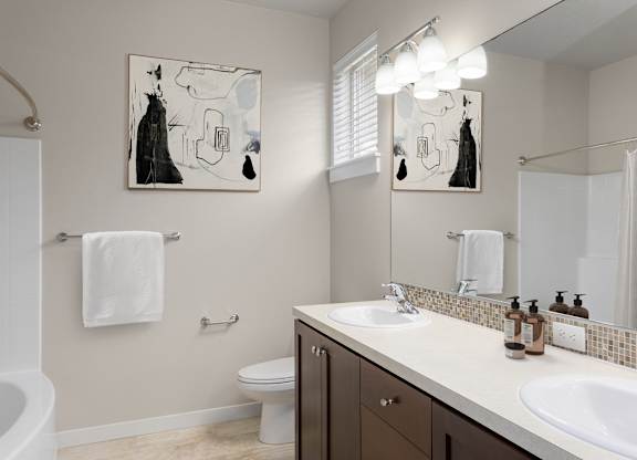A bathroom with a toilet, sink, and mirror.