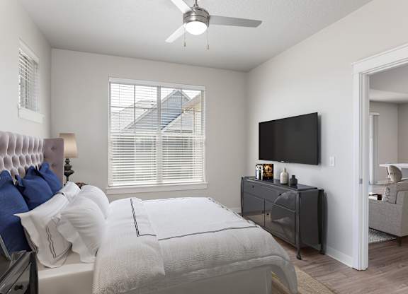 A bedroom with a bed, a dresser, and a television.