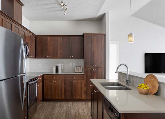 A modern kitchen with wooden cabinets and stainless steel appliances.