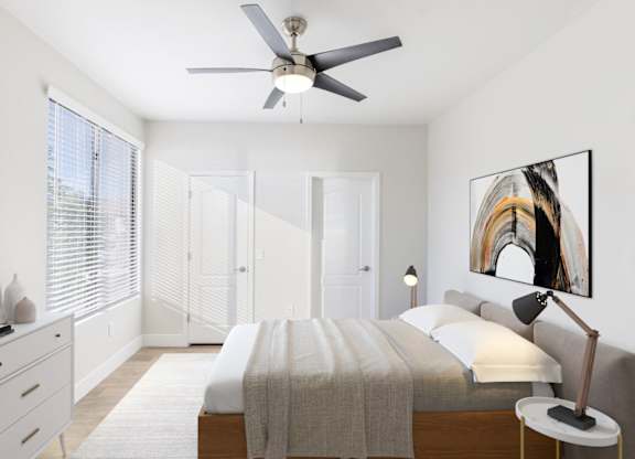 A bedroom with a bed, a ceiling fan, and a painting on the wall.