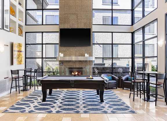 A living room with a pool table and a fireplace.