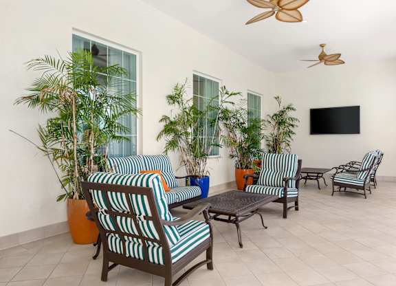 A living room with striped chairs and a flat screen TV.