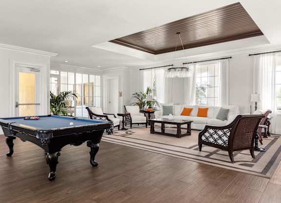 A pool table is in the middle of a living room.