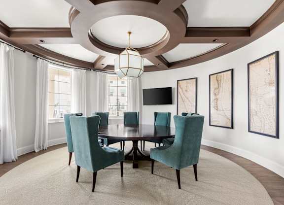A dining room with a round table and chairs.