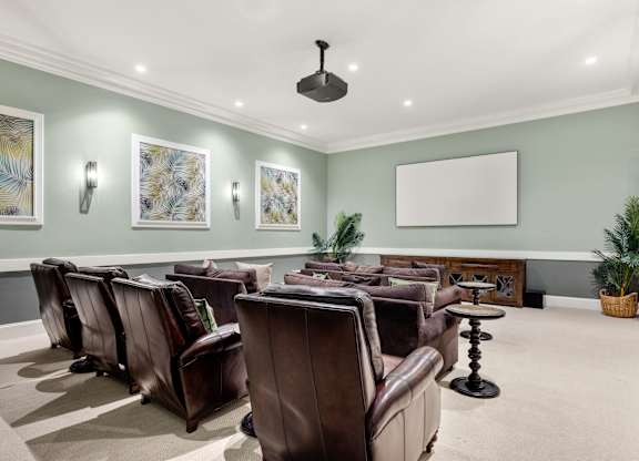 A room with brown leather chairs and a whiteboard on the wall.