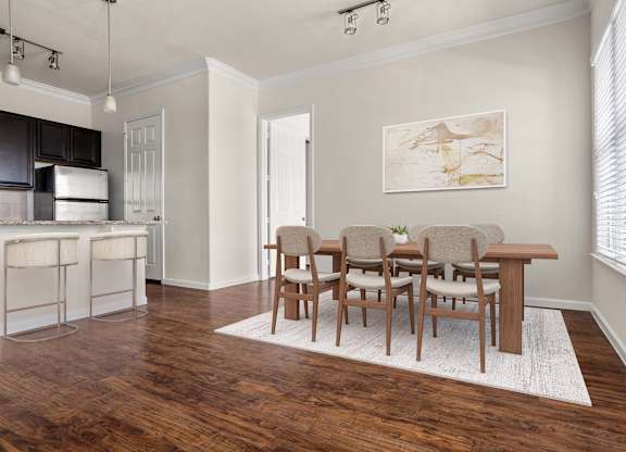 A kitchen with a bar and chairs.