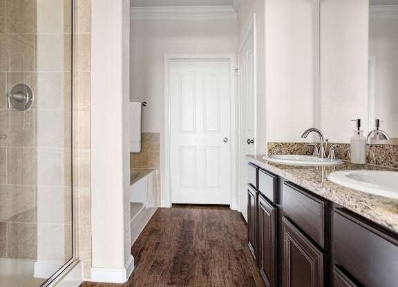 A bathroom with a walk-in shower and a white door.