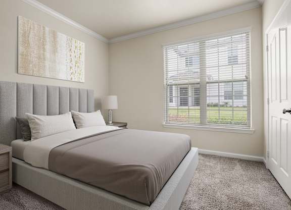 A bedroom with a large bed and a window with blinds.