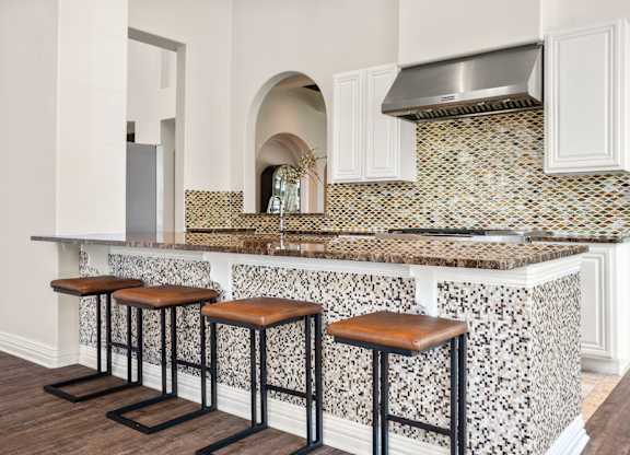 A kitchen with a bar area featuring a counter and stools.