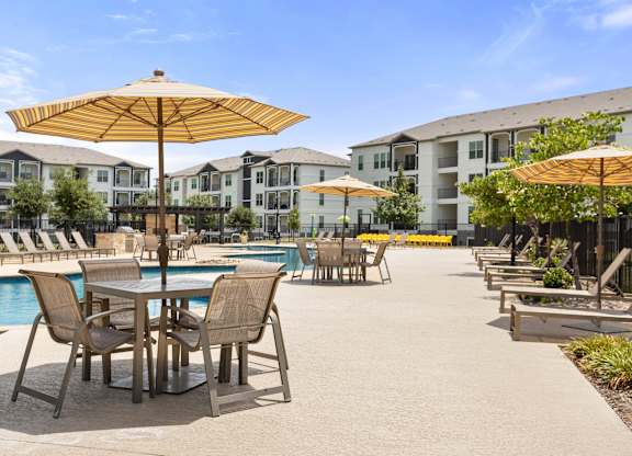 A poolside area with chairs and umbrellas.